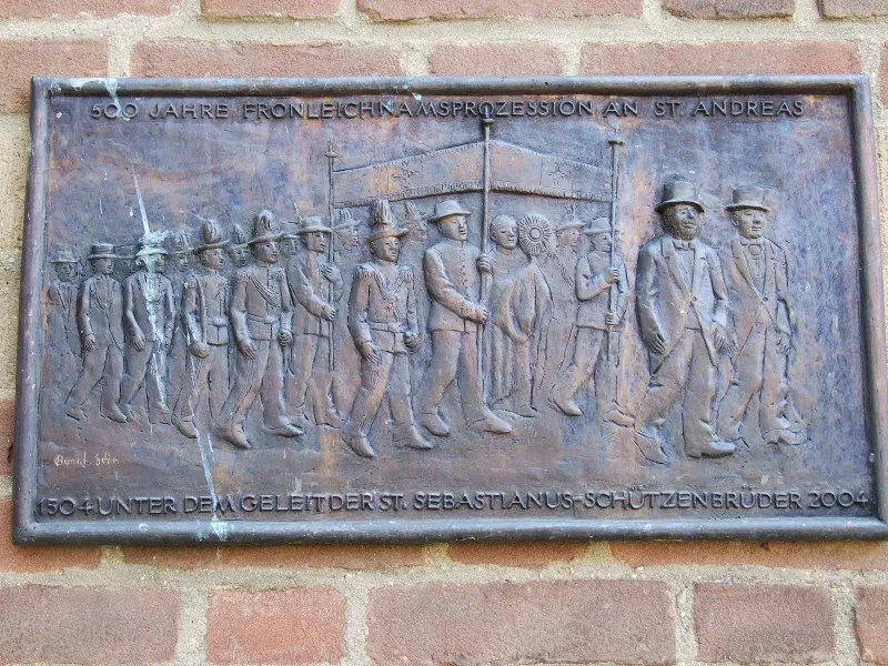 Bronzerelief: Schützen in Uniform begleiten den Traghimmel mit der Monstranz bei der Fronleichnamsprozession