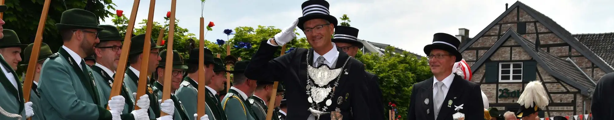 Frontabnahme durch den Schützenkönig: Schützen in grüner Uniform und Offiziere mit Zylinder